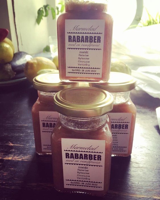Burkar med hemlagad rabarbermarmelad och etiketter som anger ingredienser och tillverkningsdatum.