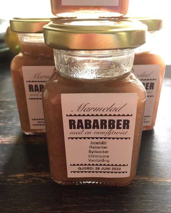 Burkar med rabarbermarmelad etiketterade "RABARBER med en vaniljtwist", tillverkningsdatum angivet.