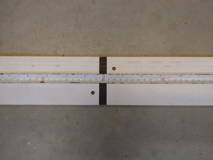 Monteringsmall med hål för löphjul och mätsticka som visar avstånd CC90.