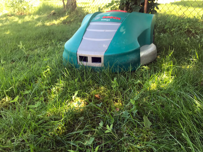 Bosch Indego robotgräsklippare på gräsmatta i felsökningsprocess och modifiering.