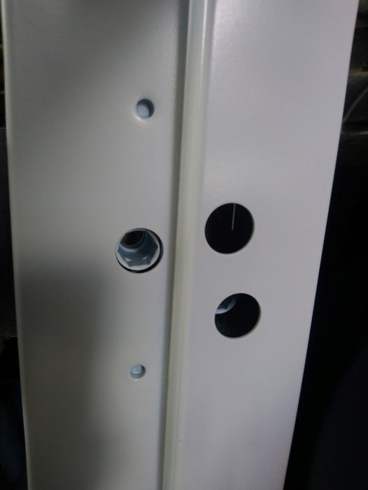 Dörrkarm med synliga karmhylsor och förborrade hål för montering mot betong.