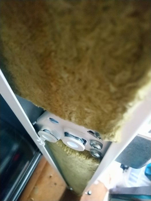 Närbild på karmhyslor monterade i en dörrkarm vid ett betongväggshål, redo för skruvinstallation.