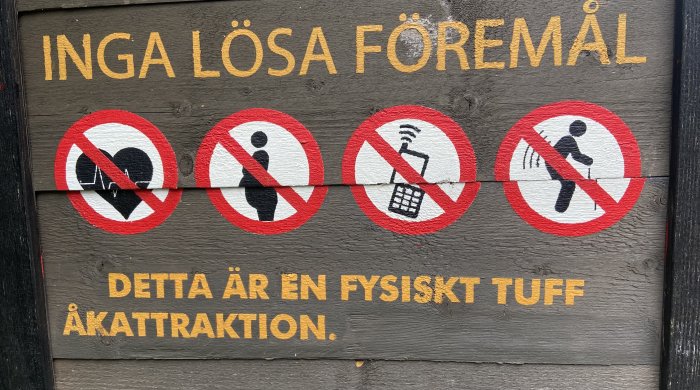 Skylt med varningstext "Inga lösa föremål" och symboler för förbud mot mat, mobil, kamera och spring.