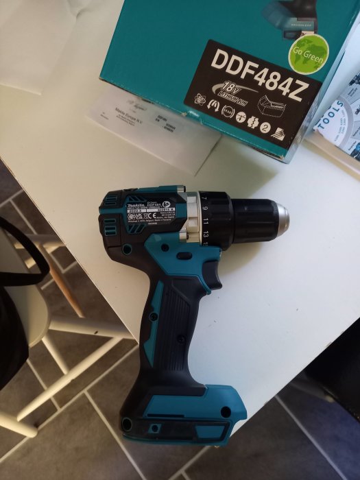 Makita DDF484Z borrskruvdragare på ett köksbord med dess kartong i bakgrunden.