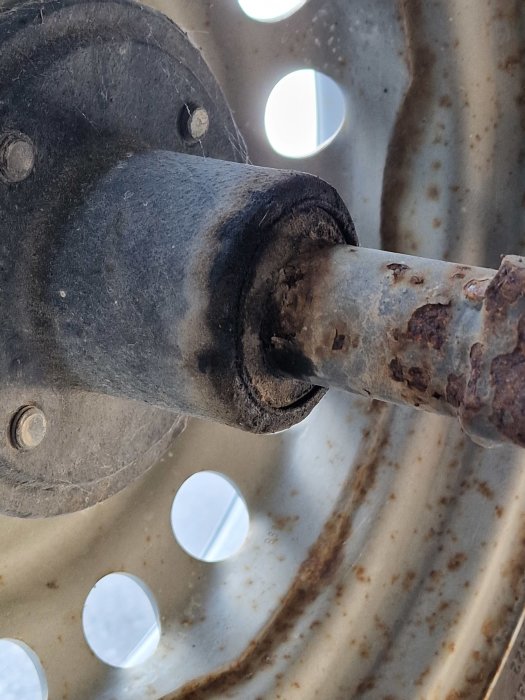 Bild på rostig hjulaxel och hjullager som behöver åtgärdas.