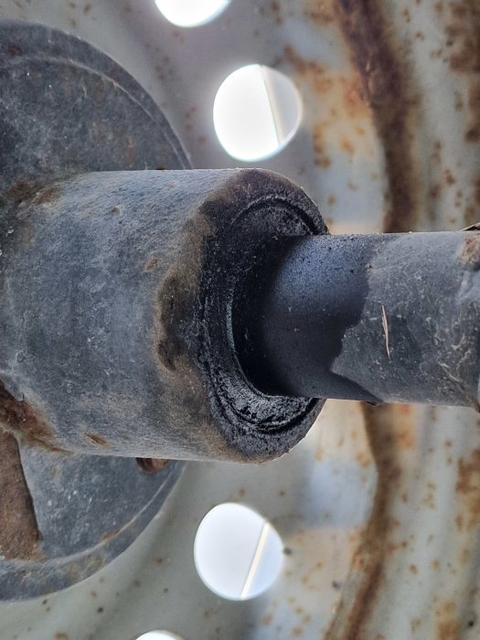 Närbild på ett slitet hjullager som behöver justeras eller bytas, synligt rost och slitage.