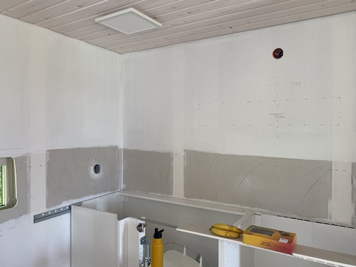 Kök under renovering med markerade ytor för 15cm kakel och 13mm gipsskiva på väggen.