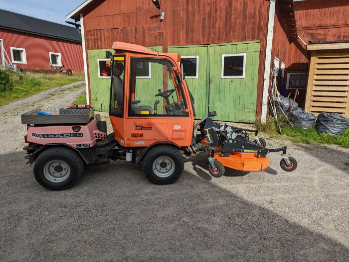 Orange Holder P240 verktygstraktor med frontlyft och klippaggregat parkerad framför en gård.