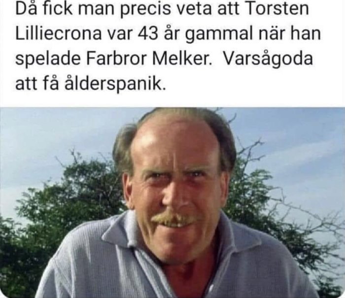 Medelålders man med mustasch ler mot kameran, träd i bakgrunden, relaterat till ålder och rollfigur.