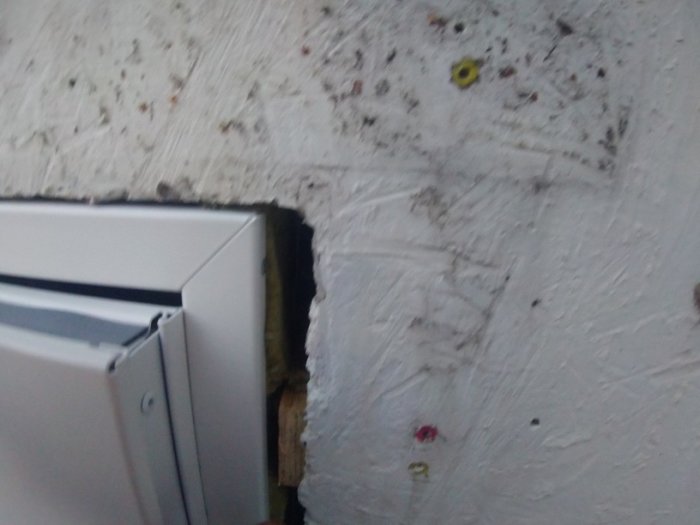 Dörrkarm monterad i vägg med synliga betongskruvar och justeringsproblem vid dörrbladet.