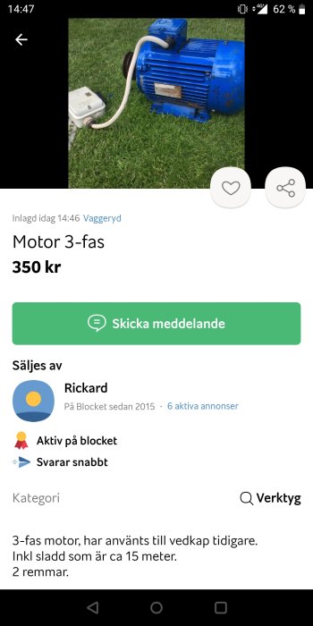 Begagnad blå 3-fas elektrisk motor med elkabel på gräsunderlag.