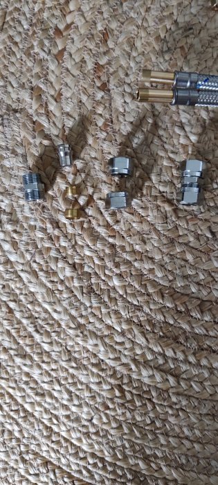 Metallkopplingar och kabeländar på vävd bakgrund.