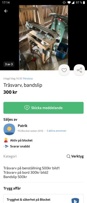 En begagnad bandslip på ett träbord i ett verkstadsutrymme, omgivet av verktyg och arbetsmaterial.