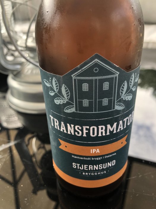 Flaska med lokal IPA-öl från Stjernsund Brygghus i Dalarna på ett bord.