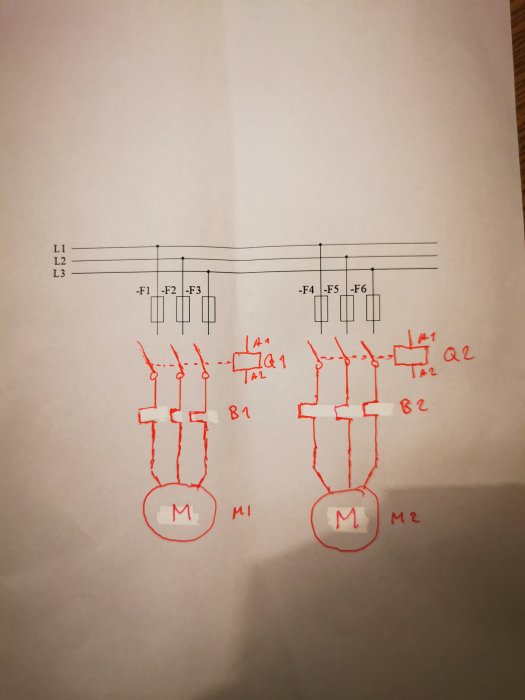 Elektriskt kretsschema med tre faser, säkringar och två motorer anslutna, ritat med röd penna på papper.