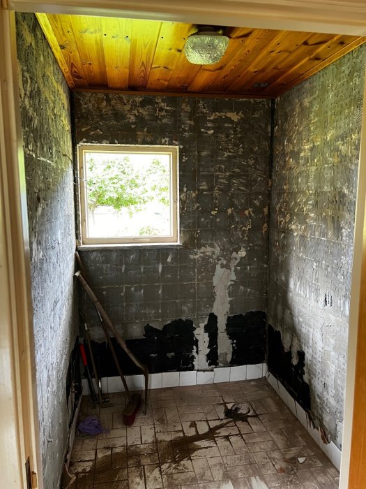 Renoveringsprojekt visande ett badrum under rivning med avlägsnade plattor och en del synlig isolering.