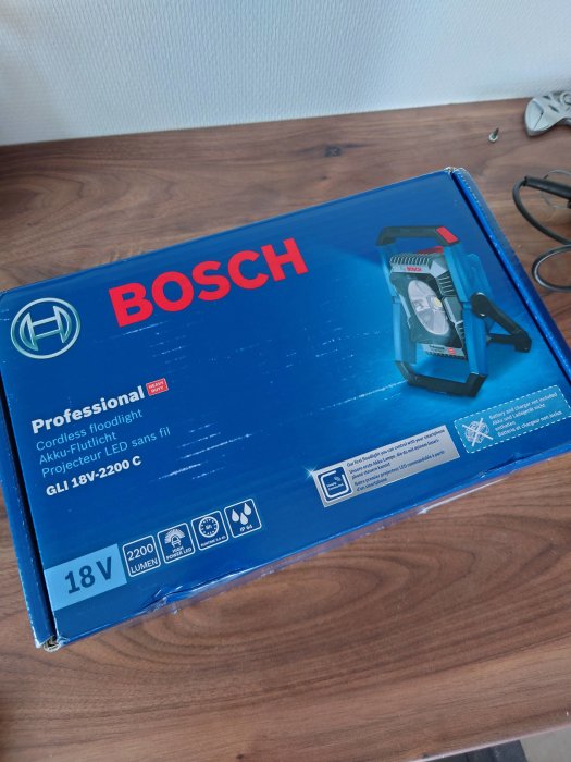 Bosch Professional-cordless floodlight förpackning på ett bord, indikerar köp av ny arbetslampa.