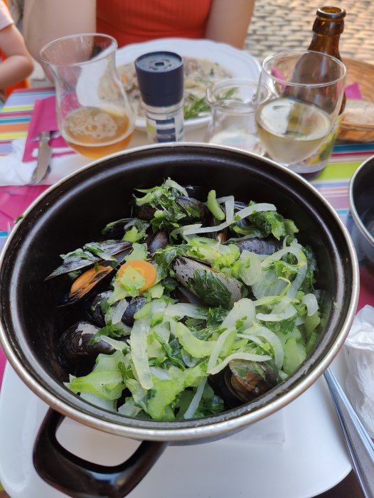 En gryta med belgiska musslor och grönsaker, serverad med öl och vin.