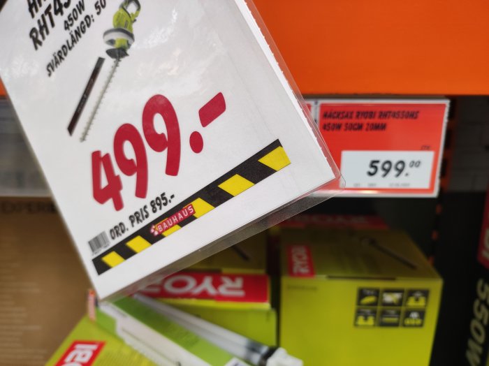 Reapris-skylt som visar 499 kr medan bakgrunden visar ett högre pris på 599 kr för samma produkt.