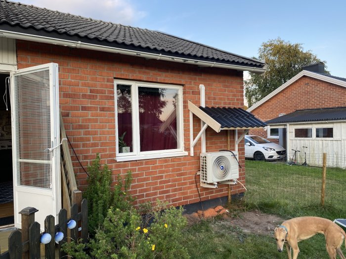 Huset med en nybyggd träkonstruktion ovanför en luftkonditioneringsenhet, ment som ett snörasskydd.