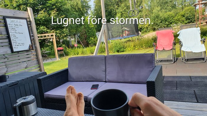 Utsikt från en uteplats med soffa, kaffekopp i förgrunden och text "Lugnet före stormen" i bild.