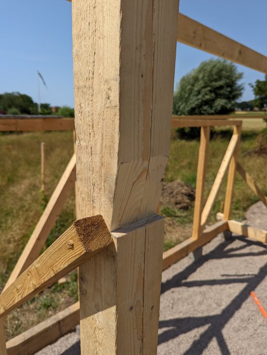 Anslutning där en träås är infogad i ett urtag på en stolpe i ett byggprojekt.