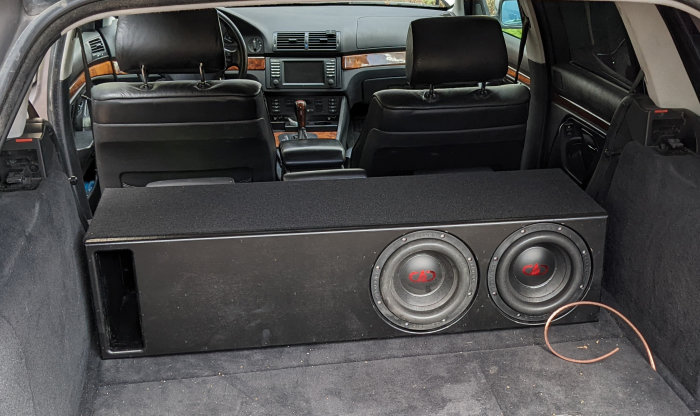 Hemsnickrad baslåda med två DD608-subwoofers i bagageutrymmet på en bil.