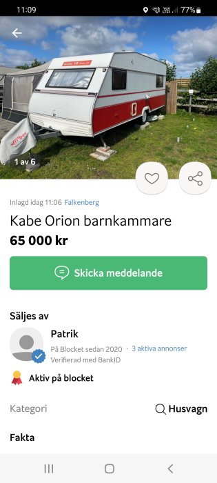 Röd och vit KABE Orion husvagn parkerad utomhus, använts som barnkammare, med förtält delvis synligt.