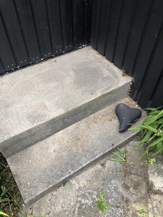 Betongtrappa med slätad yta vid hörn, svart strykjärn ligger på marken bredvid.