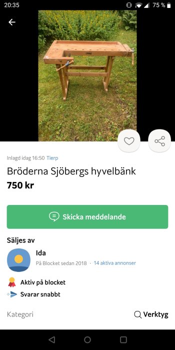 En Sjöbergs hyvelbänk i trä mot en bakgrund av grönska och blommor.