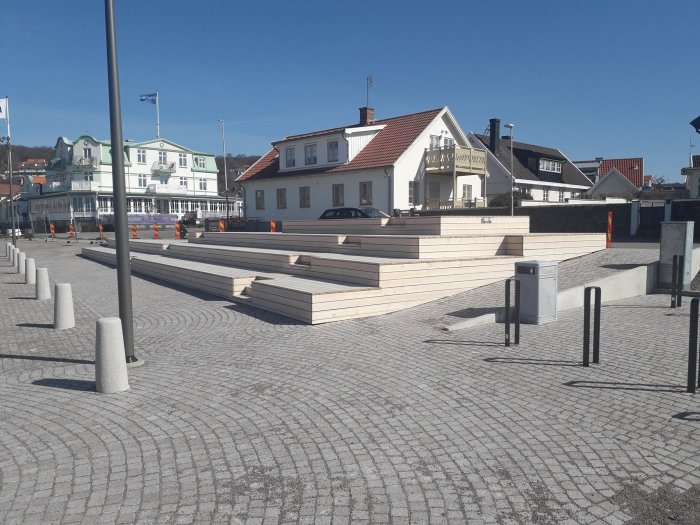 Gradäng i organowood i Mölle hamn med mörka fläckar och tecken på röta, mot hus och klarblå himmel.