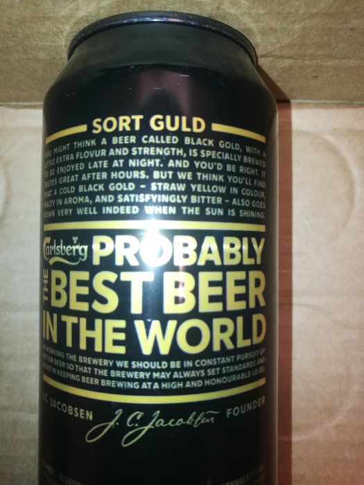 Närbild av en Carlsberg ölflaska med text "Probably the best beer in the world".