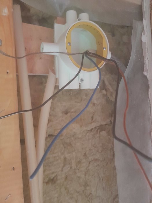 Installation av vägguttag med PVC-rör och elektriska kablar i ett pågående byggprojekt.