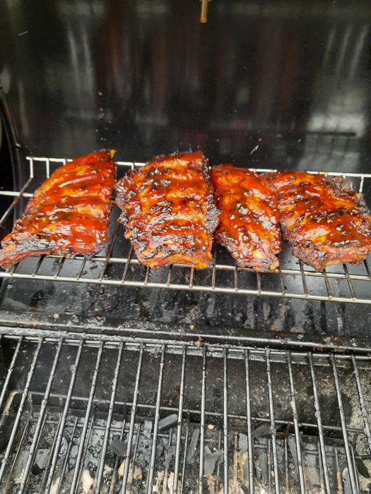 Glaserade revbensspjäll på grillen redo att gotta sig lite längre.