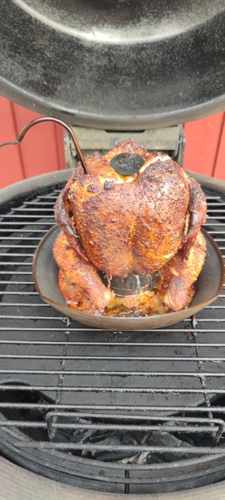 Kyckling stekt på grillen över en ölburk.