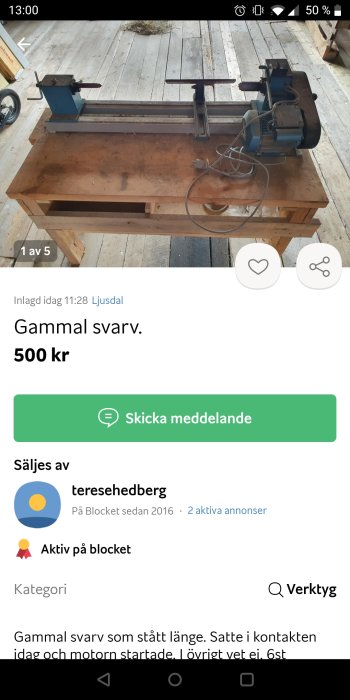 Gammal blå och svart svarv på ett brunt arbetsbord i ett utrymme med trägolv.