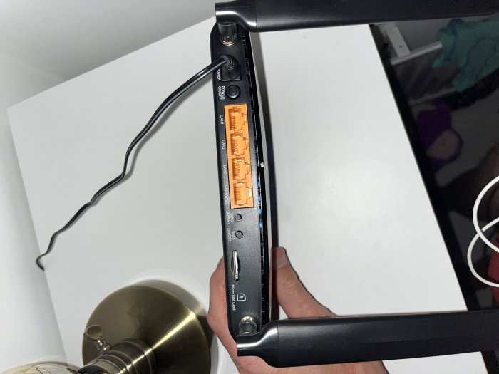 Baksida av en router med anslutna kablar och synliga portar.