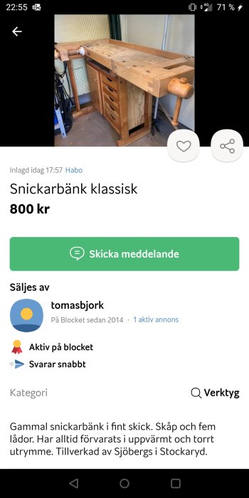 Klassisk snickarbänk i trä med skåp och lådor samt en stor skruvstäd, ställd i en verkstadslokal.