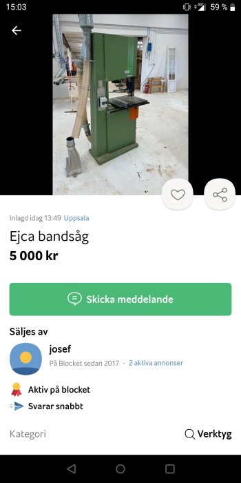 En vertikal grön bandsåg i en verkstad, säljes begagnad på annonsplatsen.