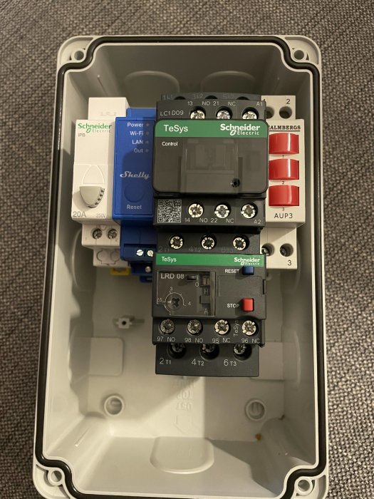 Elektrisk styrbox med komponenter från Schneider, inklusive kontaktorer och en Wi-Fi LAN-enhet.