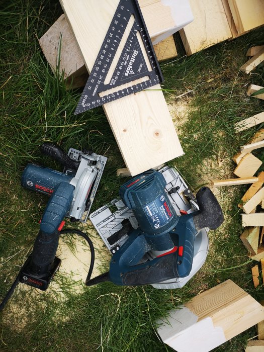 Färsågat träpanel, tving och Bosch verktyg på gräsmark.