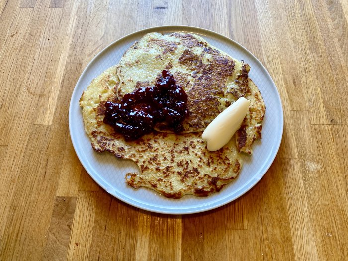 Hemlagade rårakor på en tallrik med lingonsylt och en klick smör, serverades traditionellt.