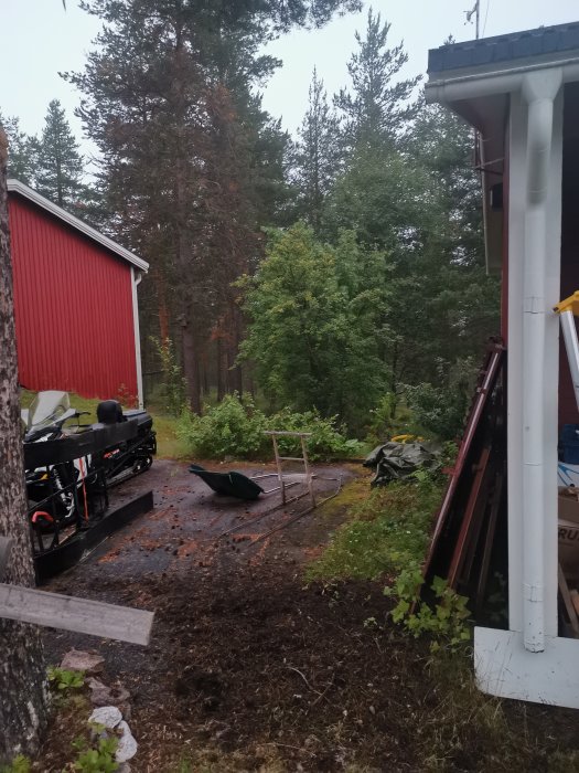 Rensat material från hängränna på marken, skogsmiljö i bakgrunden.