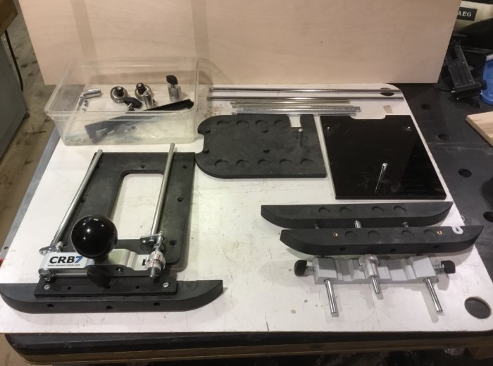 Delar av ett CRB-7 system utlagt på ett bord, inklusive guideplattor, stänger och inställningsverktyg.