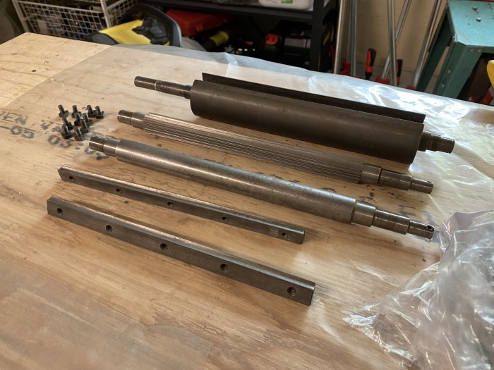 Metallaxlar och remskivor på arbetsbänk, rengjorda och redo för ytterligare renovering.