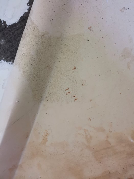 Baksidan av en plastmatta med smuts och fläckar.