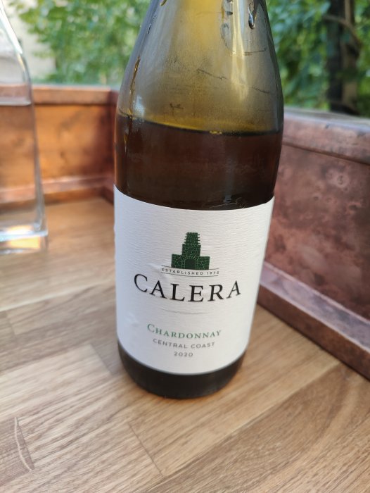 Flaska ekfatslagrad Calera Chardonnay årgång 2020 på ett bord.