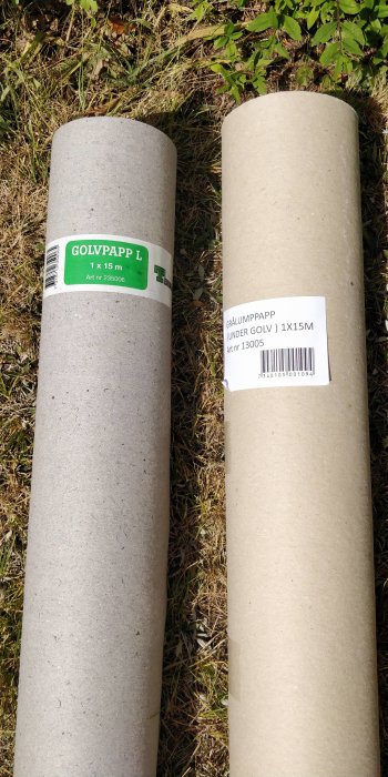 Två rullar golvpapp på gräs, den ena märkt "GOLVPAPP" och den andra "GRÄLUMPAPP".