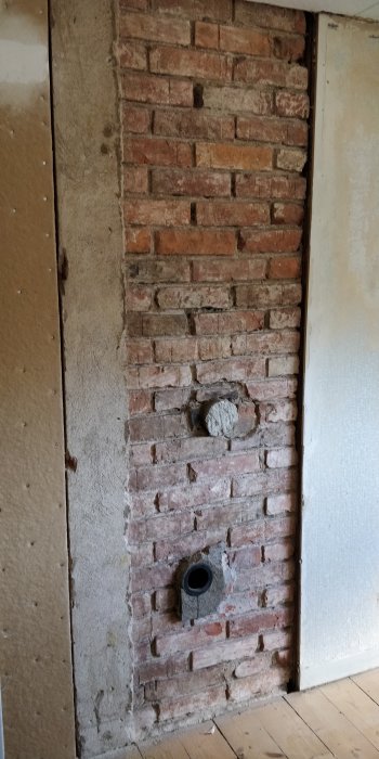 Avtäckt tegelvägg med synlig ventilation genom väggen i ett renoveringsprojekt.