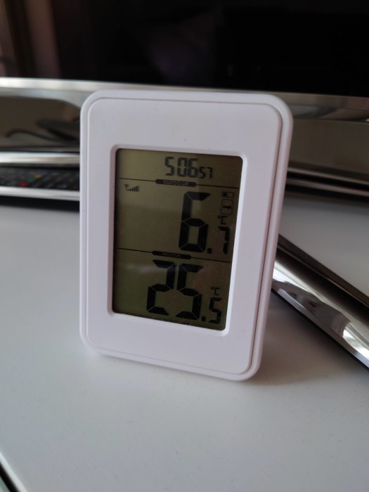 Digital termometer visar inomhus- och utomhustemperatur med 20,5 °C inomhus och 6,4 °C utomhus.